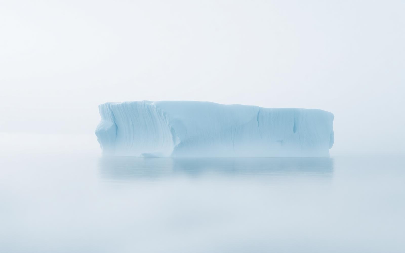 A distant iceberg lost in arctic fog